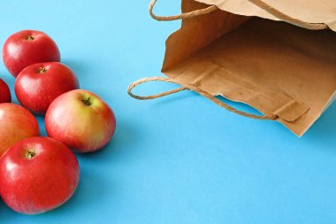 yeşil zemin üzerinde kırmızı elma ve kağıt torba, yeşil market konsepti, sıfır atık kavramı