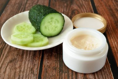 Salatalık kozmetik krem yüz ve gümüş arka planda el, cilt ve vücut bakım kremi nemlendirici losyon