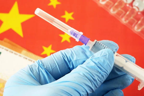 China flag, syringes with coronavirus vaccine and euro money, money for purchase and production vaccine, import chinese vaccine closeup
