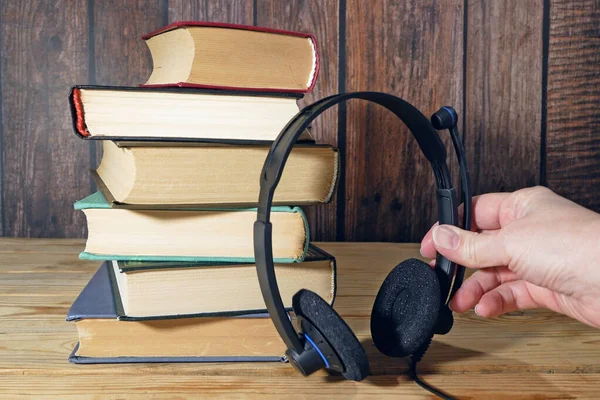 Stack of books and headphones, many books piles, online eduction, audio books concept