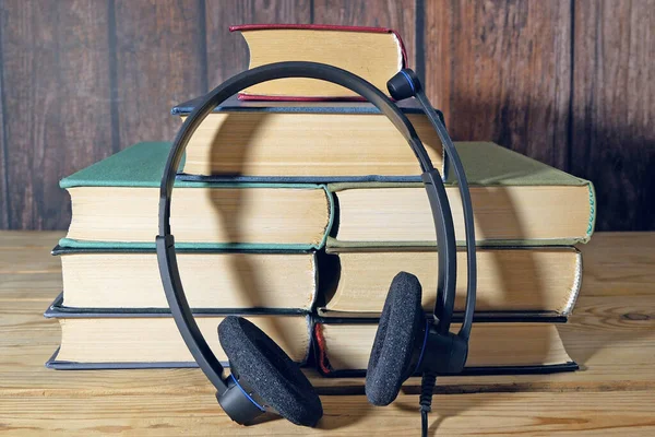 Stack of books and headphones, many books piles, online eduction, audio books concept