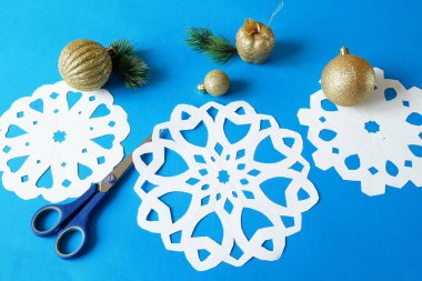 Kar taneleri kağıt işçiliği, mavi arka planda el yapımı yeni yıl süslemesi, xmas havası.