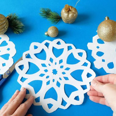 Kar taneleri kağıt işçiliği, mavi arka planda el yapımı yeni yıl süslemesi, xmas havası.