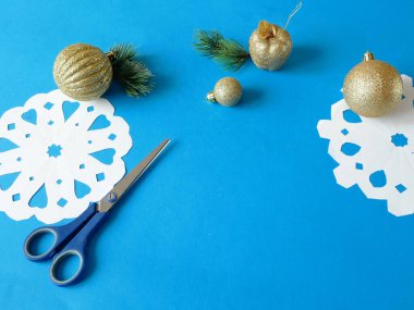 Kar taneleri kağıt işçiliği, mavi arka planda el yapımı yeni yıl süslemesi, xmas havası.
