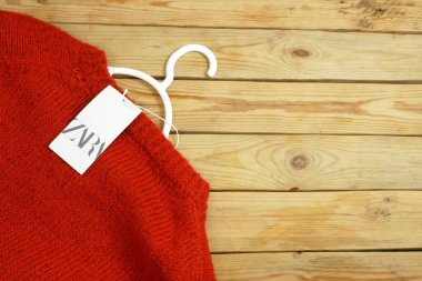 kırmızı süveter ahşap arka planda asılı Zara etiketli fotokopi alanı, kış satış konsepti