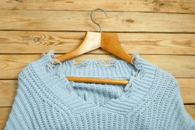 Ahşap arka planda kırmızı etiketli süveterler, kış satış konsepti, yakın plan.