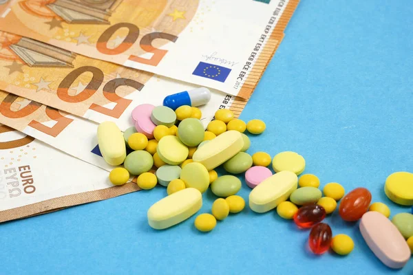 pill and drugs pour out of the bottle on money. money for treatment concept