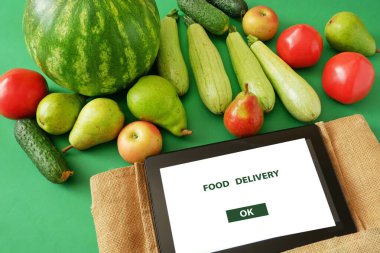 Organik sebzeler ve meyveler pamuk torbası ve tablet bilgisayar, çevrimiçi pazar, ev konseptinde yeşil market teslimatı