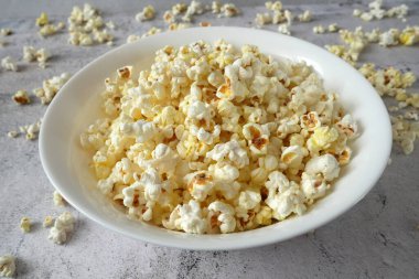 Beyaz kasenin üstünde lezzetli patlamış mısır, yakın plan.