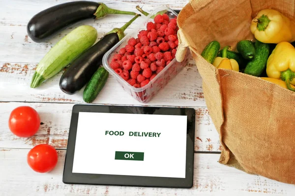 Organic Vegetables and fruits in cotton bag and tablet pc, online market, green grocery delivery at home concept