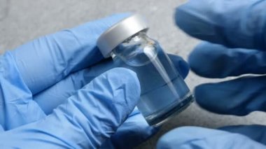 Coronavirus aşısı şişeli tıbbi eldivenleri teslim et.