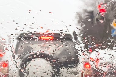 Arabalar hafif, trafik ışığı, kavşaktaki yayalar yağmurlu, soyut arka planda, bulanık yollarda.