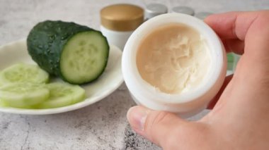 Salatalık kozmetik krem yüz ve gümüş arka planda el, cilt ve vücut bakım kremi nemlendirici losyon