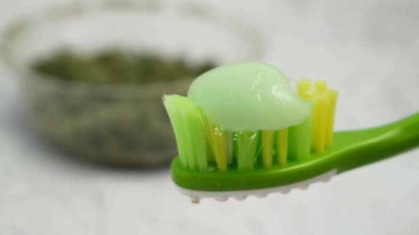 Kräuterzahnpasta Mit Zahnbürste Auf Grauem Hintergrund Cannabis Kosmetikkonzept — Stockvideo