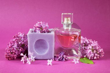 parfüm, sabun ve esans eflatun arkaplanda çiçekler, yakın plan