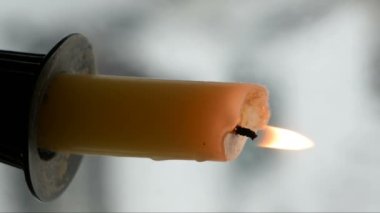 Kışın karlı bir günde pencere eşiğinde mum yakmak.