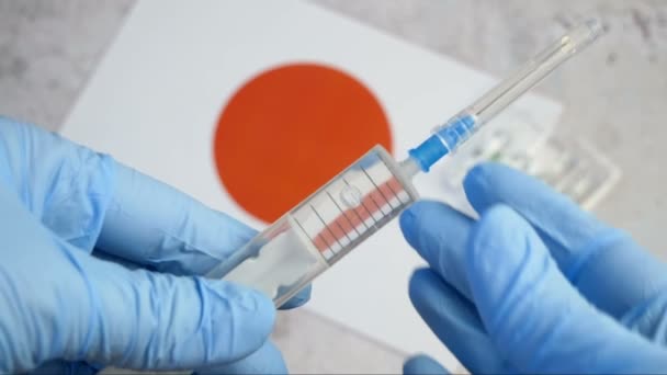 Kovid Vakcinával Ellátott Fecskendőt Kézzel Tartják Japán Zászló Hátterében Lévő — Stock videók