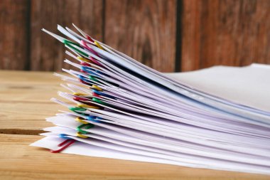 El, cilt klipsli doküman yığınını alır tahta masa, yakın plan