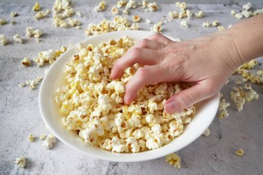 Lezzetli patlamış mısırı al ve beyaz kâsenin üstüne koy.