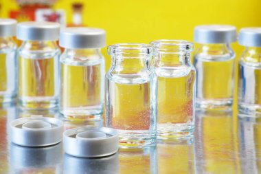 İspanya bayrağı arka planında covid-19 aşısına karşı aşılı şişe ve şırıngalar, İspanya 'da koronavirüse karşı aşılama kavram olarak başladı, kapanış