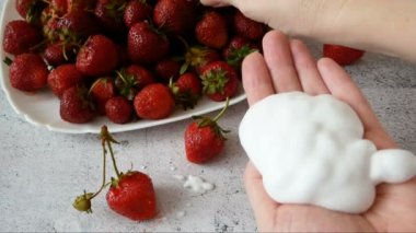 Kavanozda doğal krem kozmetik ve gri arka planda taze çilek, yakın plan.