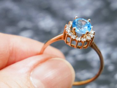 Yüzüğe mavi taşla bakan kuyumcu, mücevher kontrolü ve doğrulama, rehinci konsepti, kuyumcu dükkanı, yakın plan.