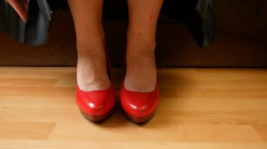 Siyah deri etekli ve kırmızı yüksek topuklu bir kadın.