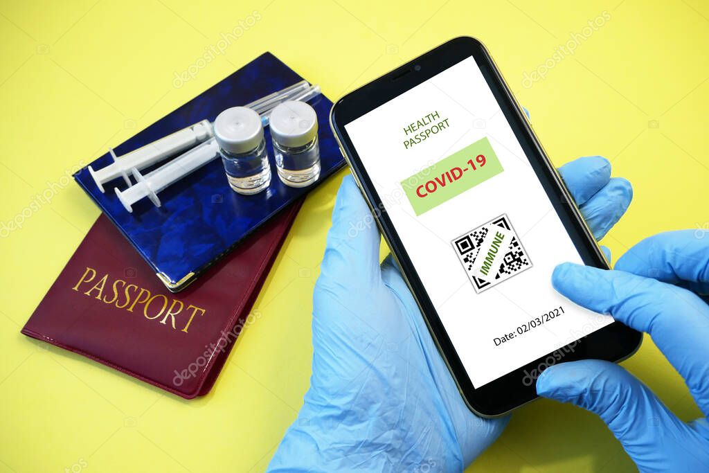 Vaccination passport on a mobile phone allowing travel in hand. Vaccination against the coronavirus Covid 19.Imunity or Health passport, closeup