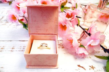 Bir hediye kutusunda alyans ve çiçek açan ağaç dalı, bahar zamanı düğün konsepti, yakın plan.