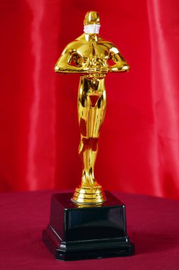 Hollywood Altın Oscar Akademisi tıp maskeli heykeli. Başarı ve zafer kavramı. Coronavirus zamanında Oscar töreni