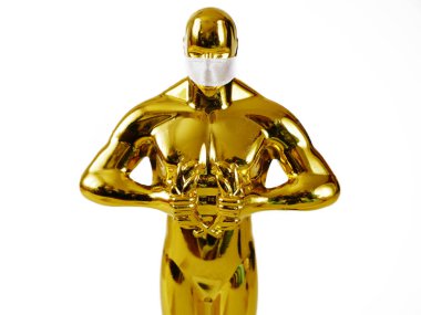 Hollywood Altın Oscar Akademisi tıp maskeli heykeli. Başarı ve zafer kavramı. Coronavirus zamanında Oscar töreni