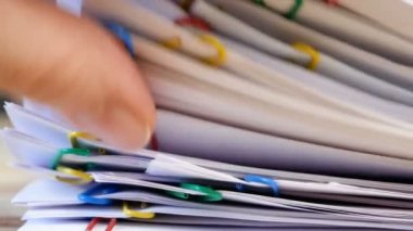 El, cilt klipsli, ahşap masalı bir yığın belge alır