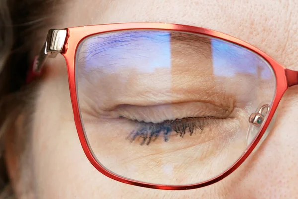 middle aged woman face in glasses with blue eyes on a blurred background eye care oncept, business woan concept, macro, closeup