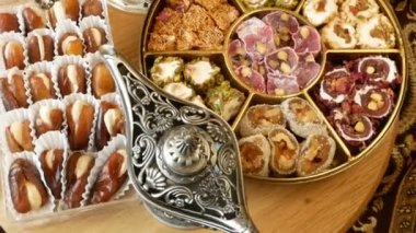 Fındık, şeker, metal vazo, çay, ahşap arka planda hurma.