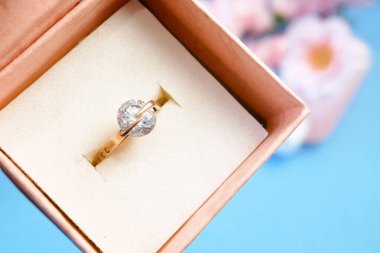 Bir hediye kutusunda alyans ve çiçek açan ağaç dalı, bahar zamanı düğün konsepti, yakın plan.