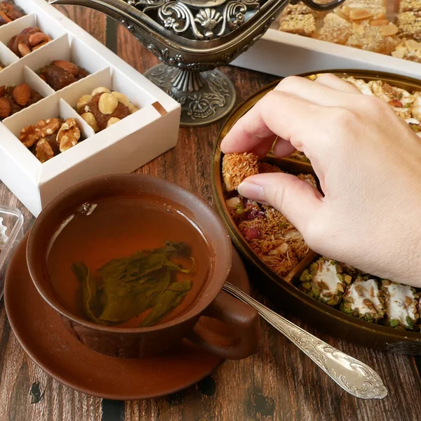 Ostersüßigkeiten Mit Nüssen Bonbons Metallvase Tee Datteln Auf Holzgrund Nahaufnahme — Stockfoto