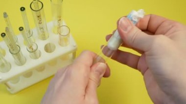 Ellerin adet bezi ya da tampon tutarken ve laboratuardaki verimliliğini kontrol ederken çekilmiş görüntüler. Adet dönemi boyunca kadınların etkin şekilde korunması