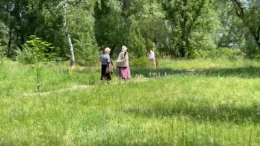 Dnipro, Ukrayna - 01.06 2021: Yaşlı kadınların yazın parkta yürüyüş görüntüleri