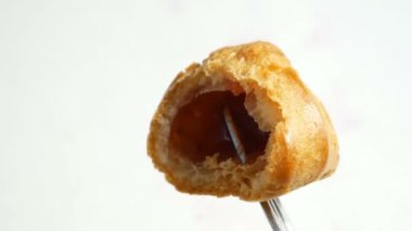 Kremalı pasta ya da beyaz arka planda çilekle doldurulmuş profiterol.