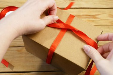 Kırmızı kurdeleli hediye paketi, kahverengi karton paket, sürpriz, yakın plan.