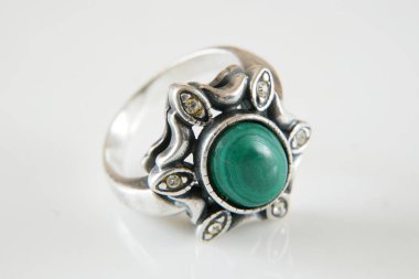 Beyaz arka planda taşla kaplanmış güzel, eski bir yüzük.