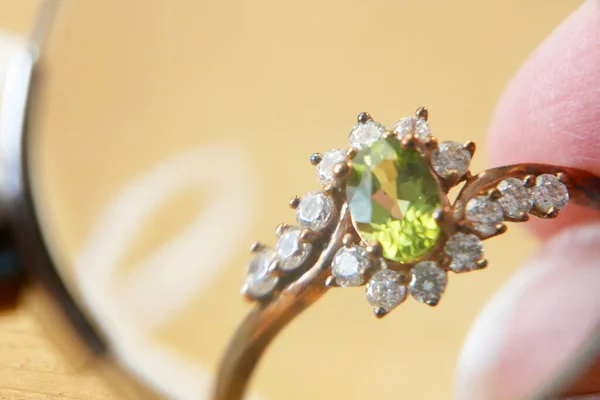 Anillo Con Piedra Peridoto Diamantes Las Manos Sobre Fondo Madera — Foto de Stock