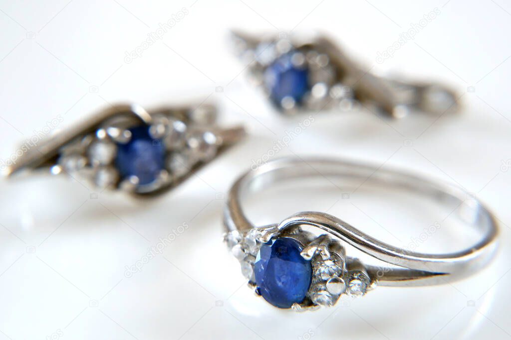 earring and ring set with big blue sapphire and white diamonds around, jewerly shop, pawnshop concept, closeup
