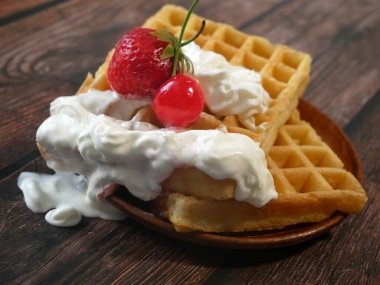 Krem şantili waffle, taze çilek meyvesi ve akçaağaç şurubu, yakın plan..