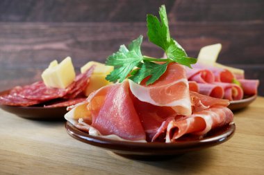 Soğuk Tütsülenmiş Et Tabağı, Antipasto, ahşap tabaklar. Dilimlenmiş jambon, jambon, jambon ve peynirli soğuk tütsülenmiş et tabağı. Uzayı kopyala Üst görünüm, yakın plan