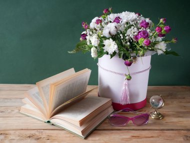 Bir yığın kitap ve sanatsal arka planda bir buket çiçek. Öğretmenler Günü. Durgun hayat