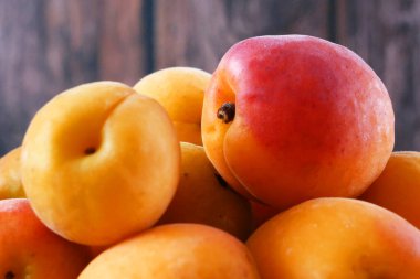 Ahşap arka planda bir sürü kayısı, yakın plan.