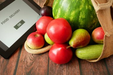 Organik sebzeler ve pamuk poşetindeki meyveler ve tablet bilgisayar, çevrimiçi pazar, ev konseptinde yeşil market teslimatı, online konsept satın al