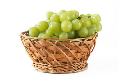 Beyaz arka planda yeşil üzüm sepeti. Bir grup yeşil üzüm seriliyor, yakın plan