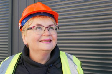 Hard Hat 'teki Kadın Mühendis dizüstü bilgisayarı depo arka planında, açık havada